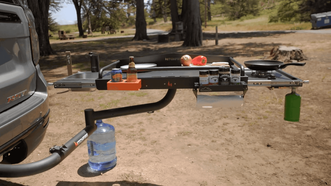 Trailer hitch with camping gear attached on a dirt road