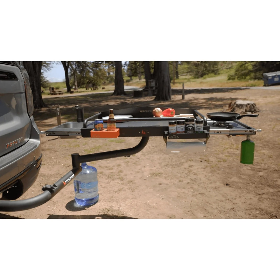 Trailer hitch with camping gear attached on a dirt road