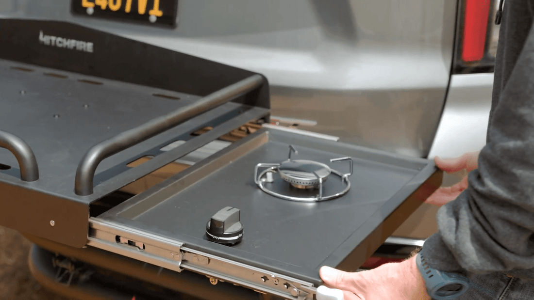Portable stove top with a person holding it next to a vehicle