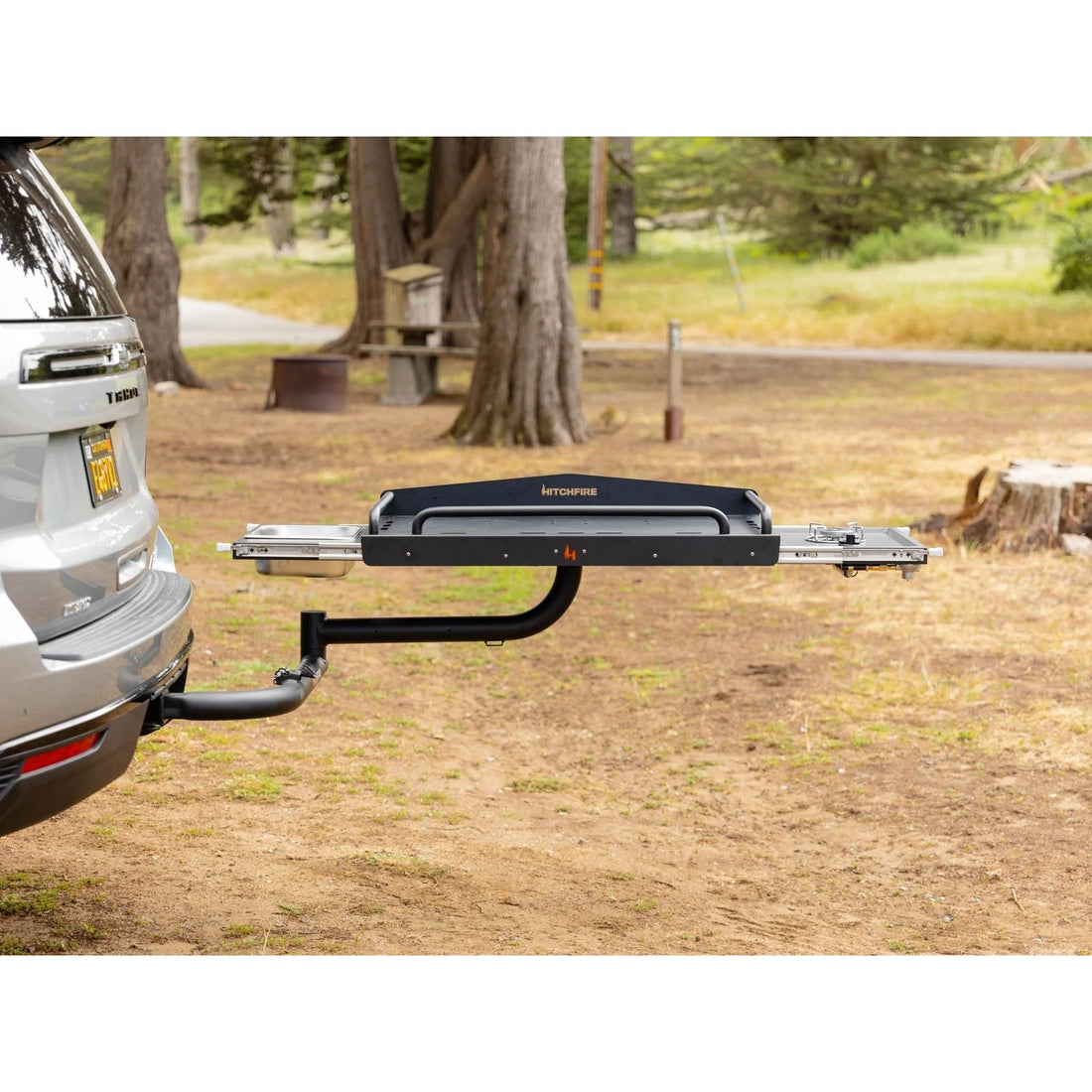 Tow bar attached to a vehicle in a natural setting with trees and grass.