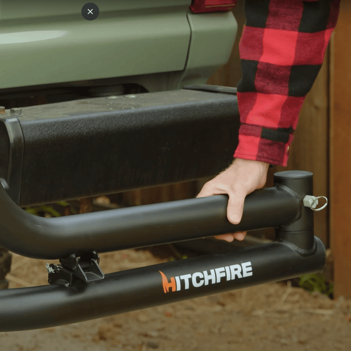 Hand swinging out the HitchFire DIY Dual Swing Arm mounted to a vehicle hitch