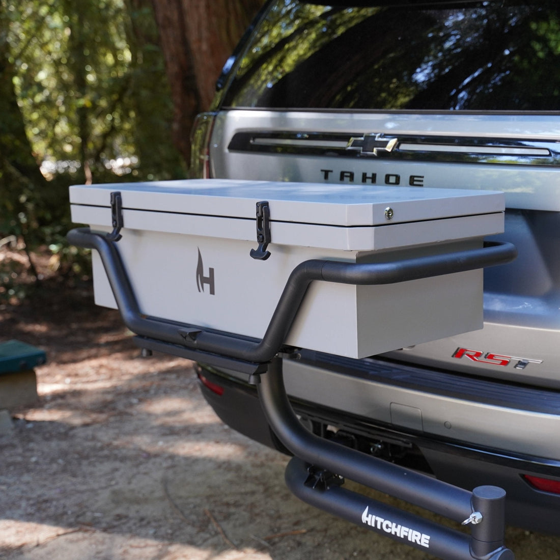 Silver Chevrolet Tahoe with a toolbox attached to the back, parked outdoors.