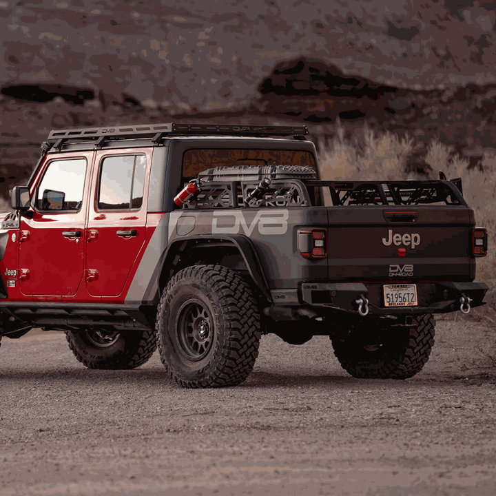 Red Jeep with a DV8 Offroad universal overland bed rack and roof rack in a desert setting.