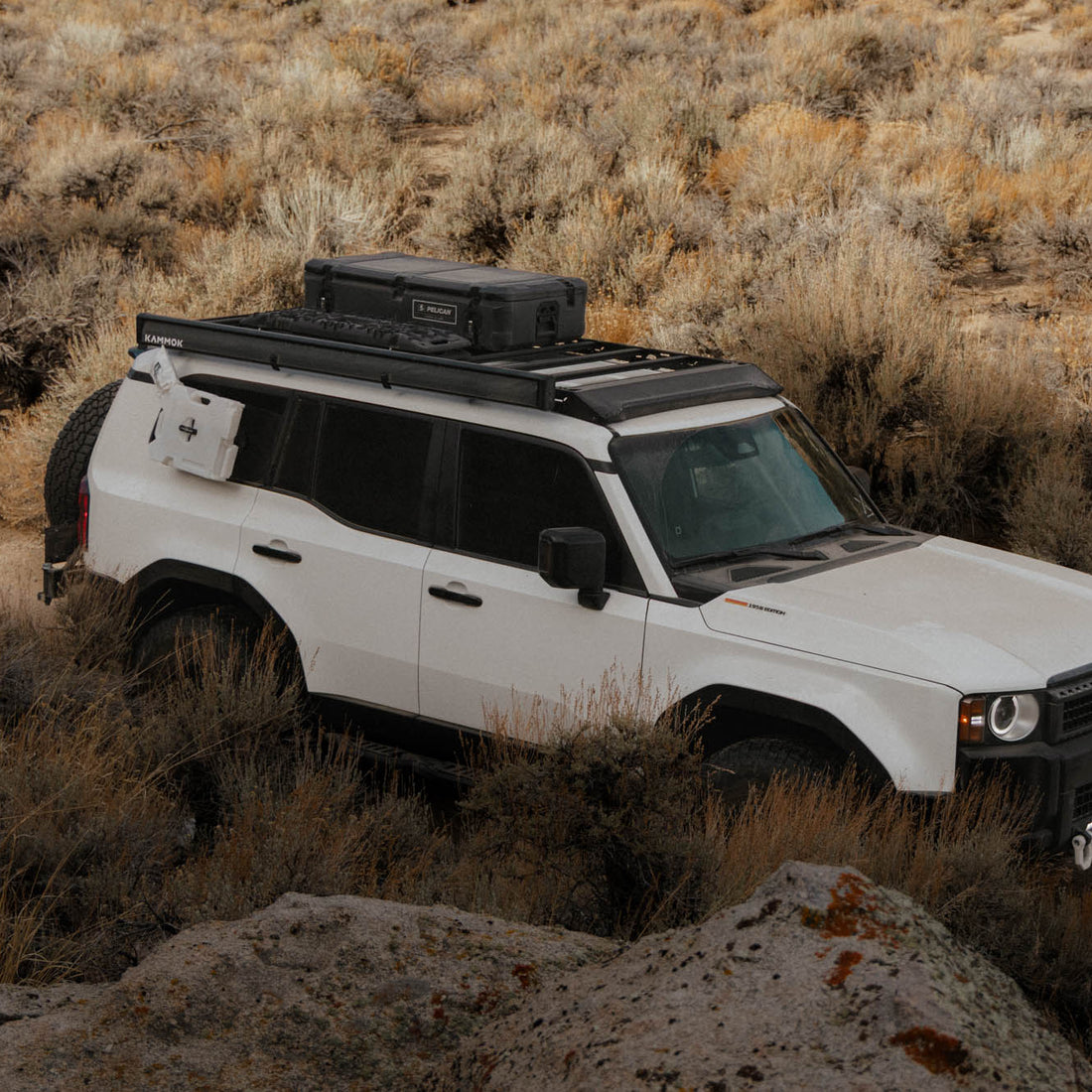 White SUV with roof rack in a desert landscape