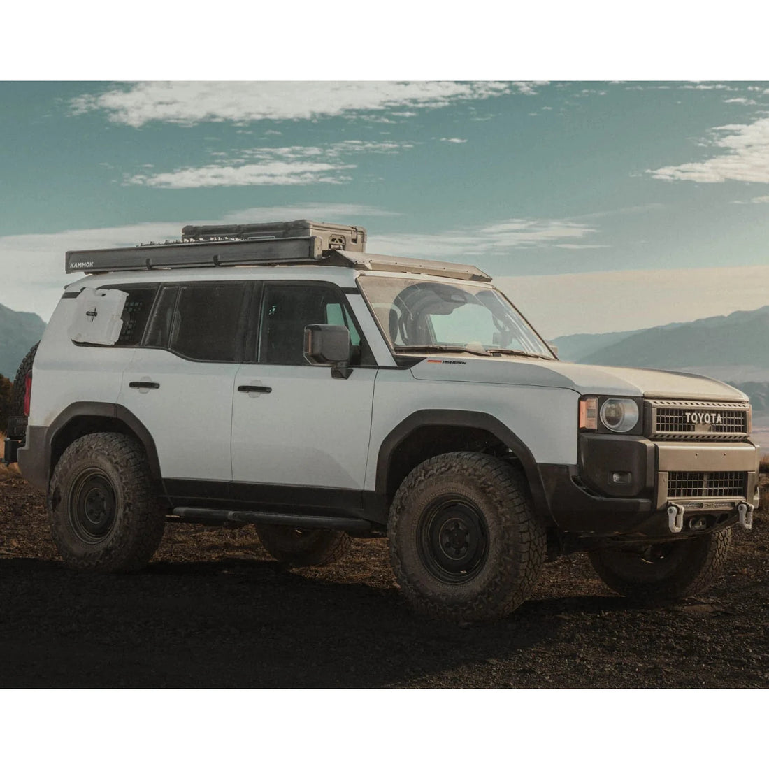 White SUV with off-road equipment in a desert landscape