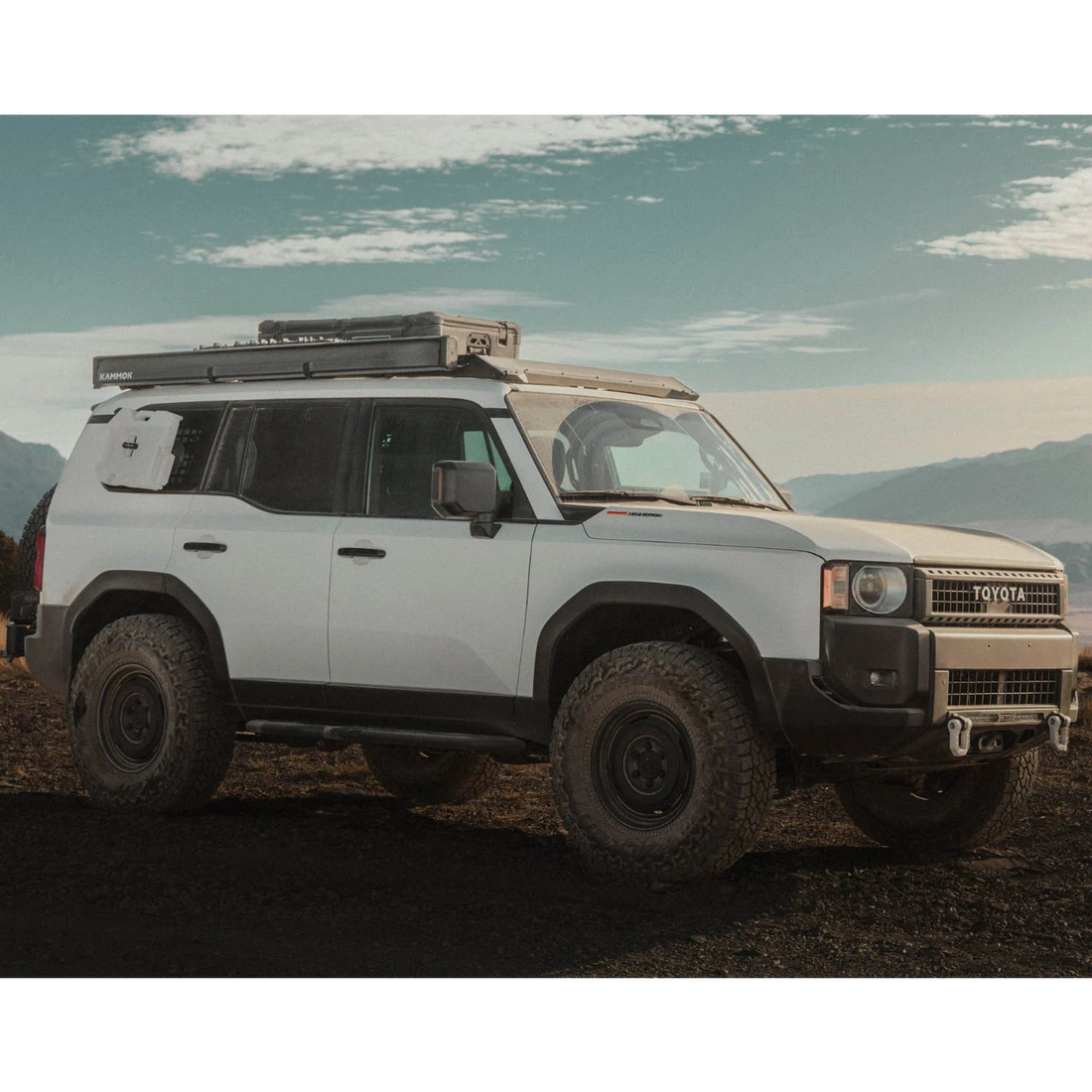 White SUV with off-road equipment in a desert landscape