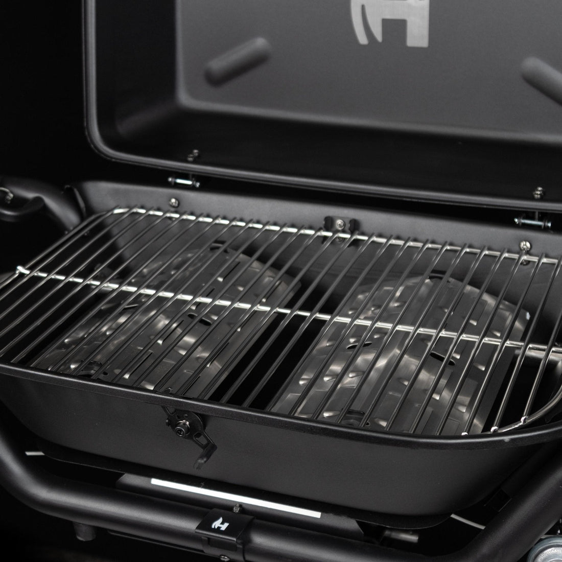 Black grill with open lid on a black background