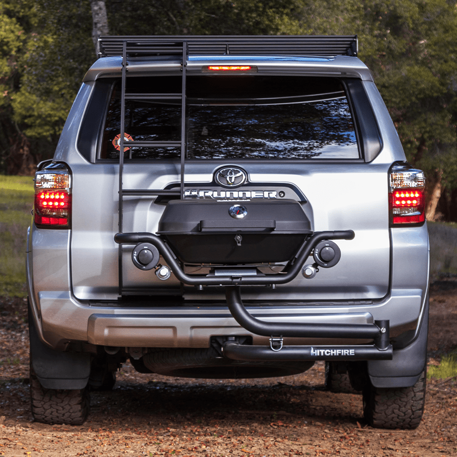 Silver Toyota truck with a roof rack and additional equipment in a forest setting