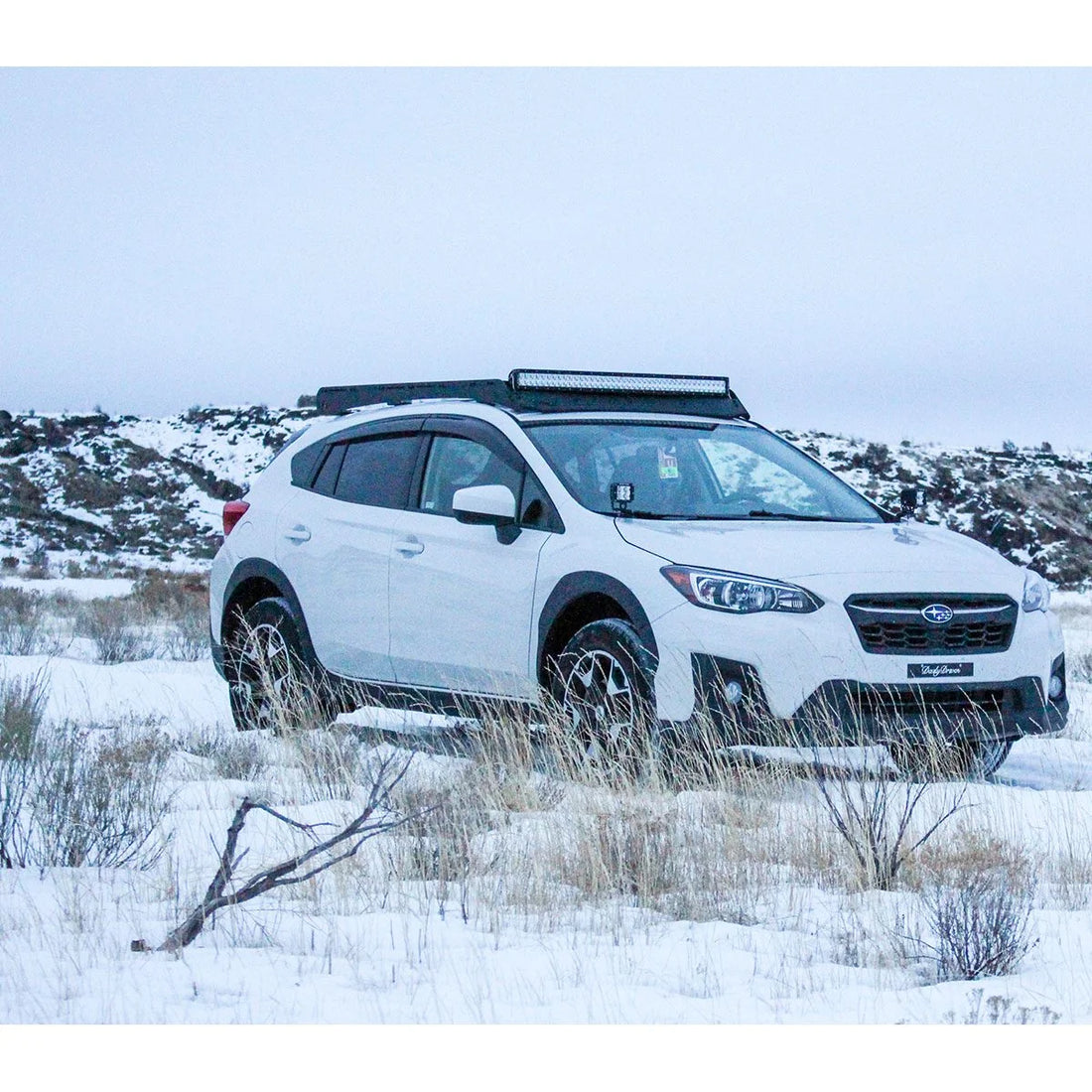 White 2nd Gen Subaru Crosstrek with Prinsu roof rack parked in the snow