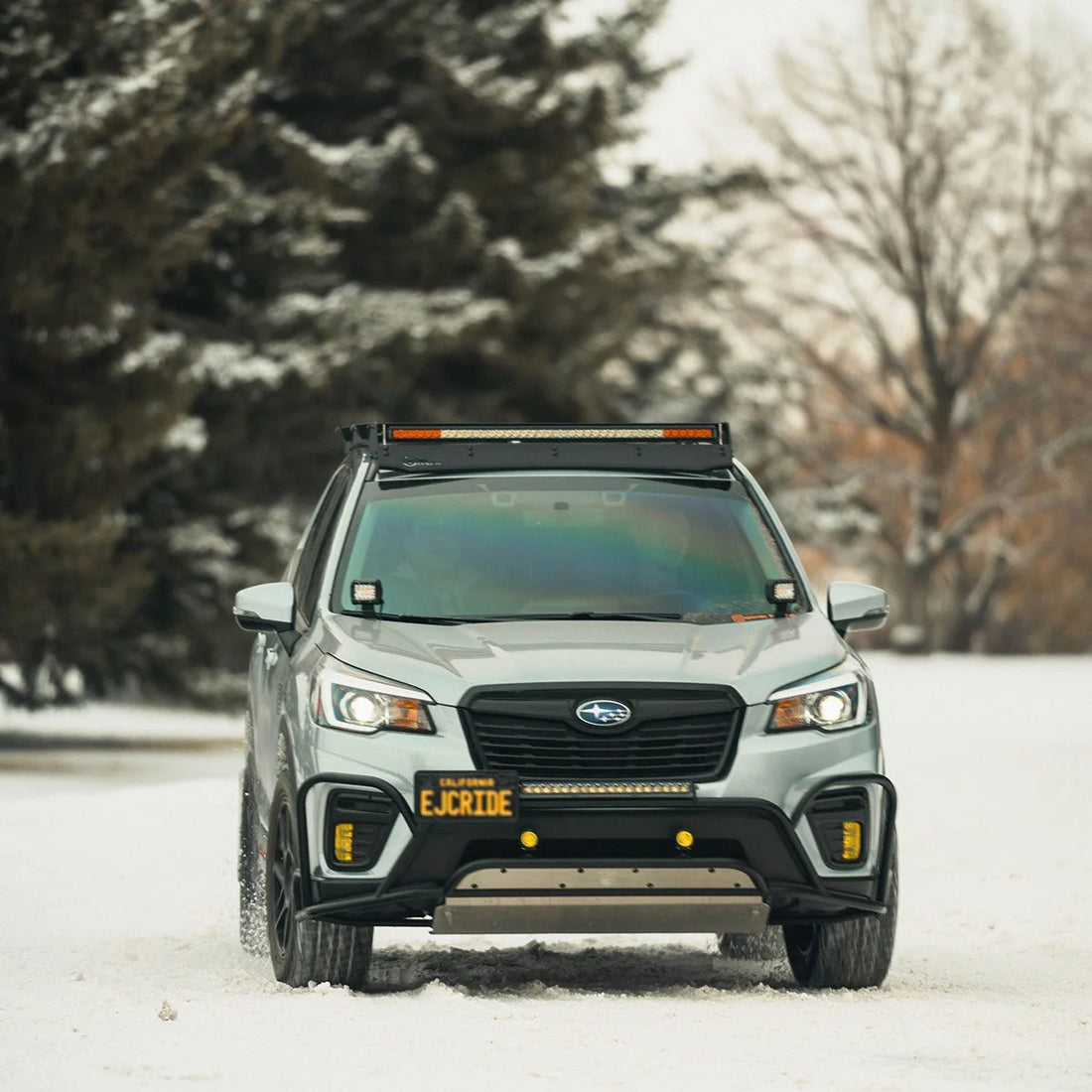 Subaru Forester with Prinsu roof rack and light bar in a snowy forest