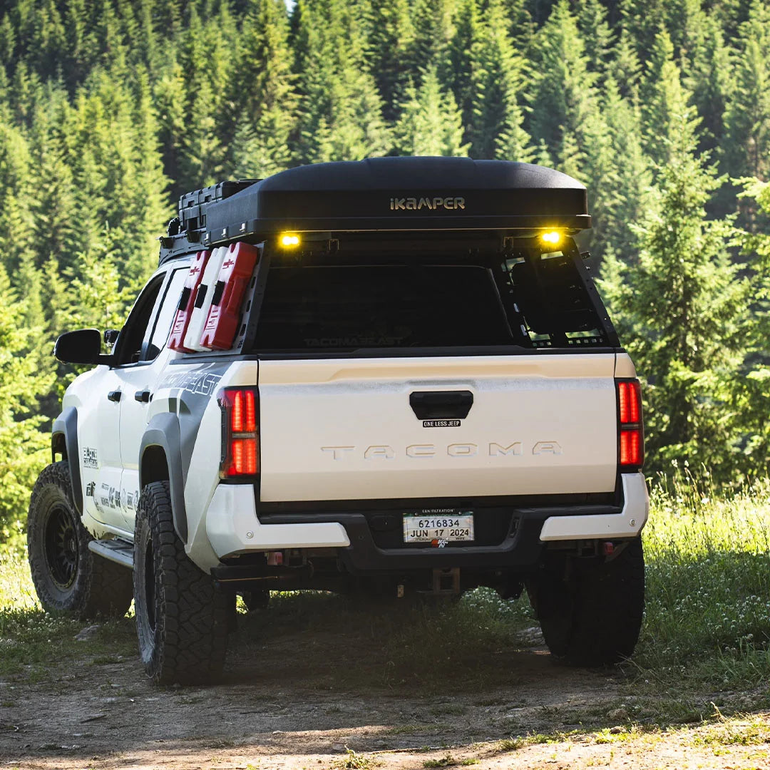 4th Gen Tacoma with CBI cab height bed rack on a forest trail