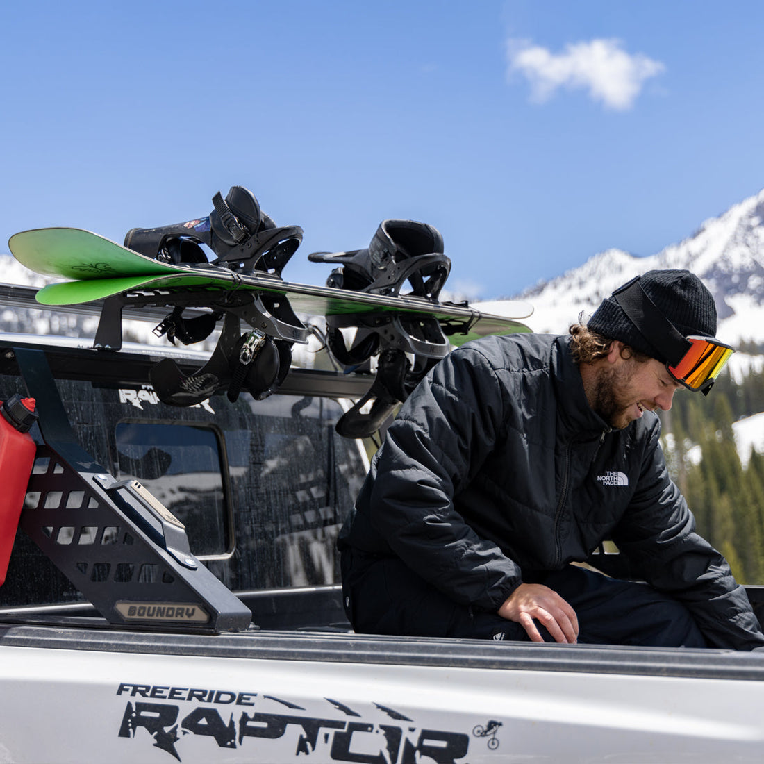 Snowboard held in a Big Days Chase Rack add-on mount with rubber strap