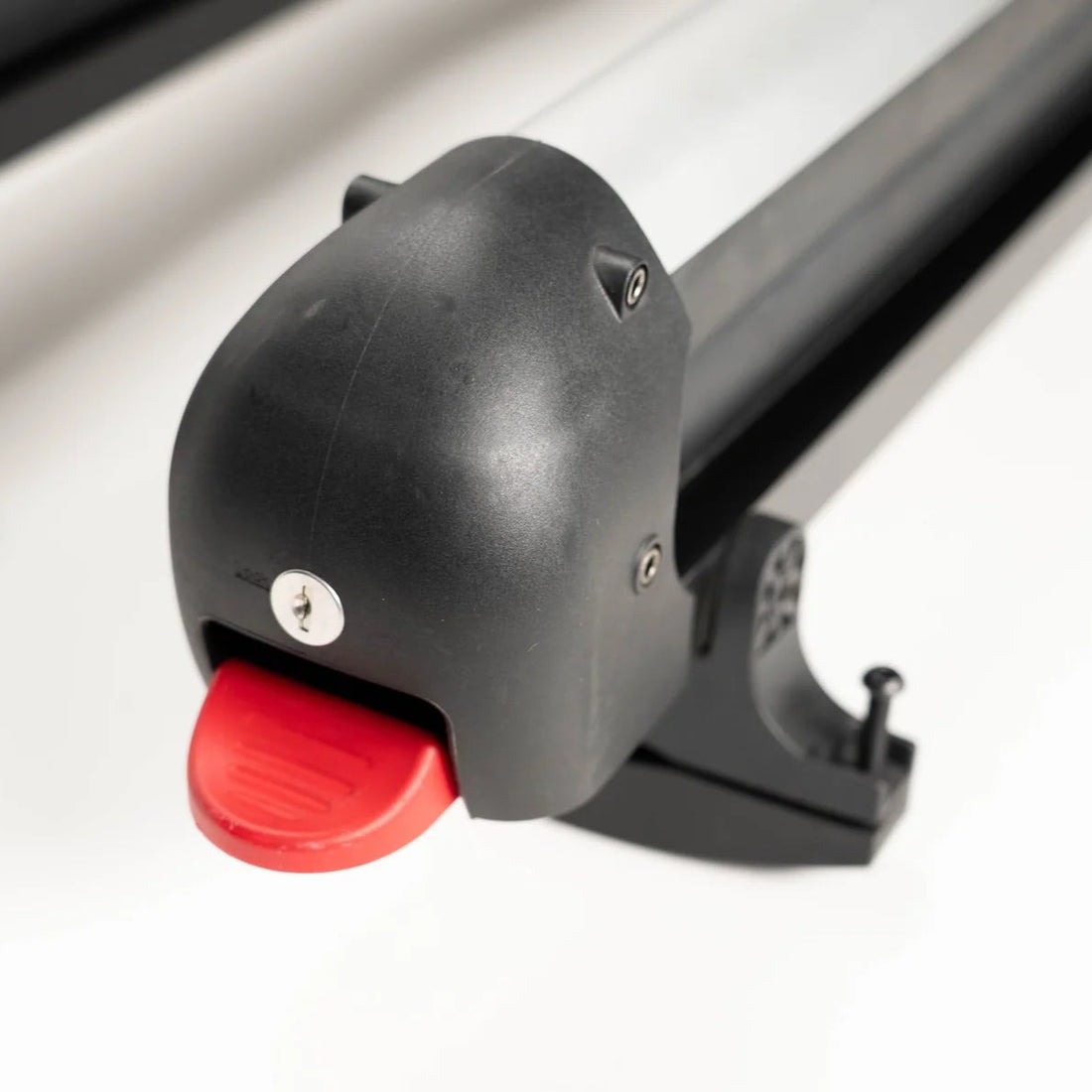 Black ski rack with a red button on a white background