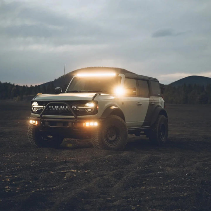 Ford Bronco equipped with a 40 inch LED light bar on the roof, illuminated during dusk or dawn.